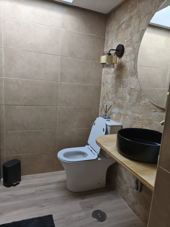 Casa de banho concluída, com revestimento em tons quentes