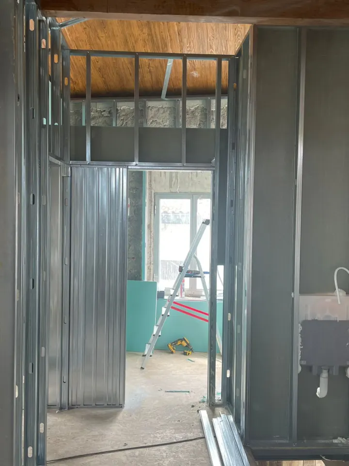 Montagem de divisórias interiores vista a partir do corredor de uma obra